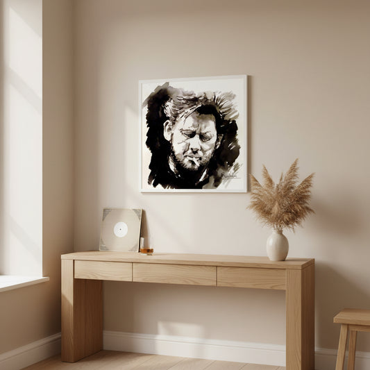 Framed Shane MacGowan print in white gallery frame hung above oak console in modern apartment with subtle folk music references and neutral colour palette.