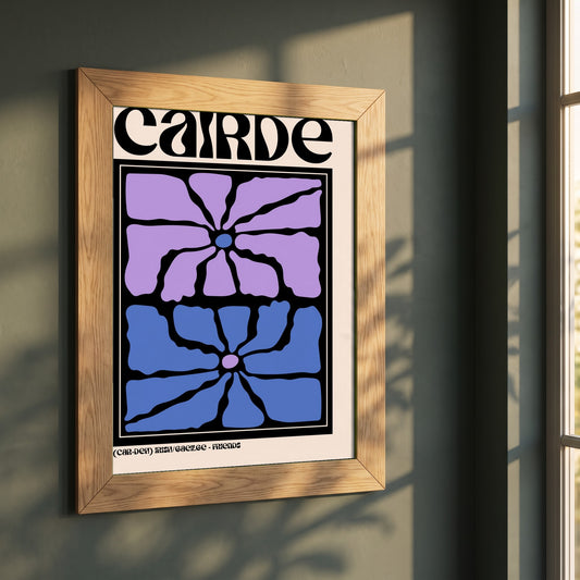 Cairde framed print in a natural oak frame on a dark green wall beside a window, dappled plant shadow