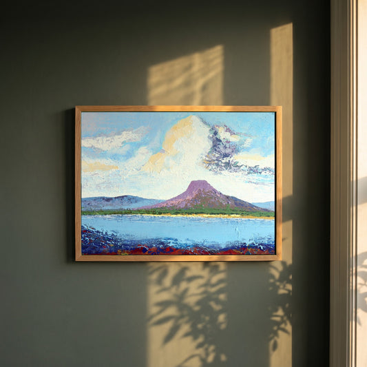 Lurig from the Shore framed print in a natural oak frame on a dark green wall beside a window, dappled plant shadow
