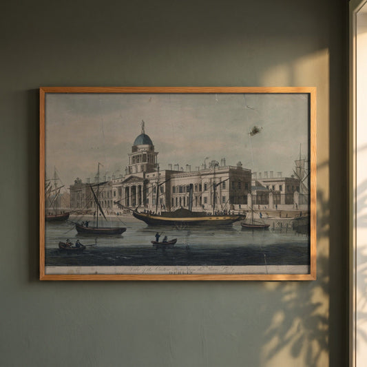 The Custom House, Dublin framed print in a natural oak frame on a dark green wall beside a window, dappled plant shadow