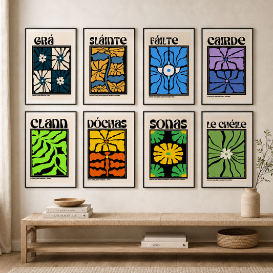 Set of 8 Irish Language Word Framed Prints on a gallery wall, abstract floral art prints in different colours are arranged in two rows on a beige wall above a wooden bench with books and a vase.