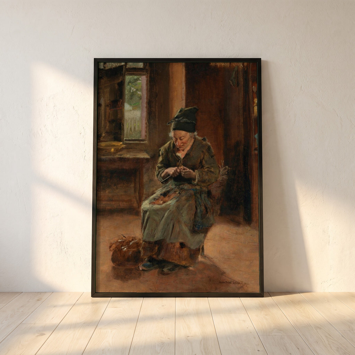 An Interior of a Breton Cottage framed print in a black frame leaning against a white plaster wall on oak floorboards in morning light