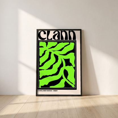 Clann framed print in a black frame leaning against a white plaster wall on oak floorboards in morning light