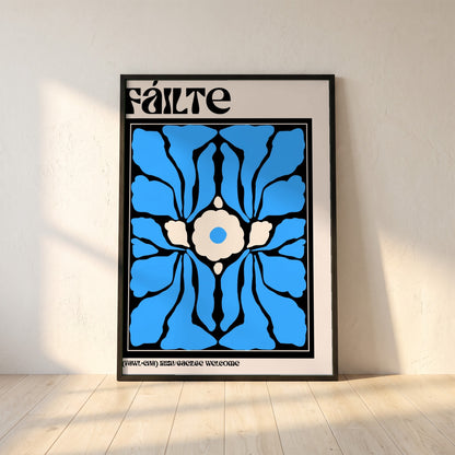 Fáilte framed print in a black frame leaning against a white plaster wall on oak floorboards in morning light