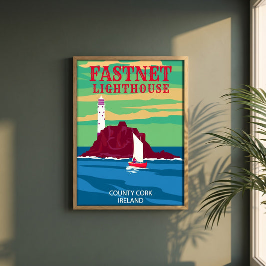 Fastnet Lighthouse retro travel poster framed print in a natural oak frame on a dark green wall beside a window, dappled plant shadow