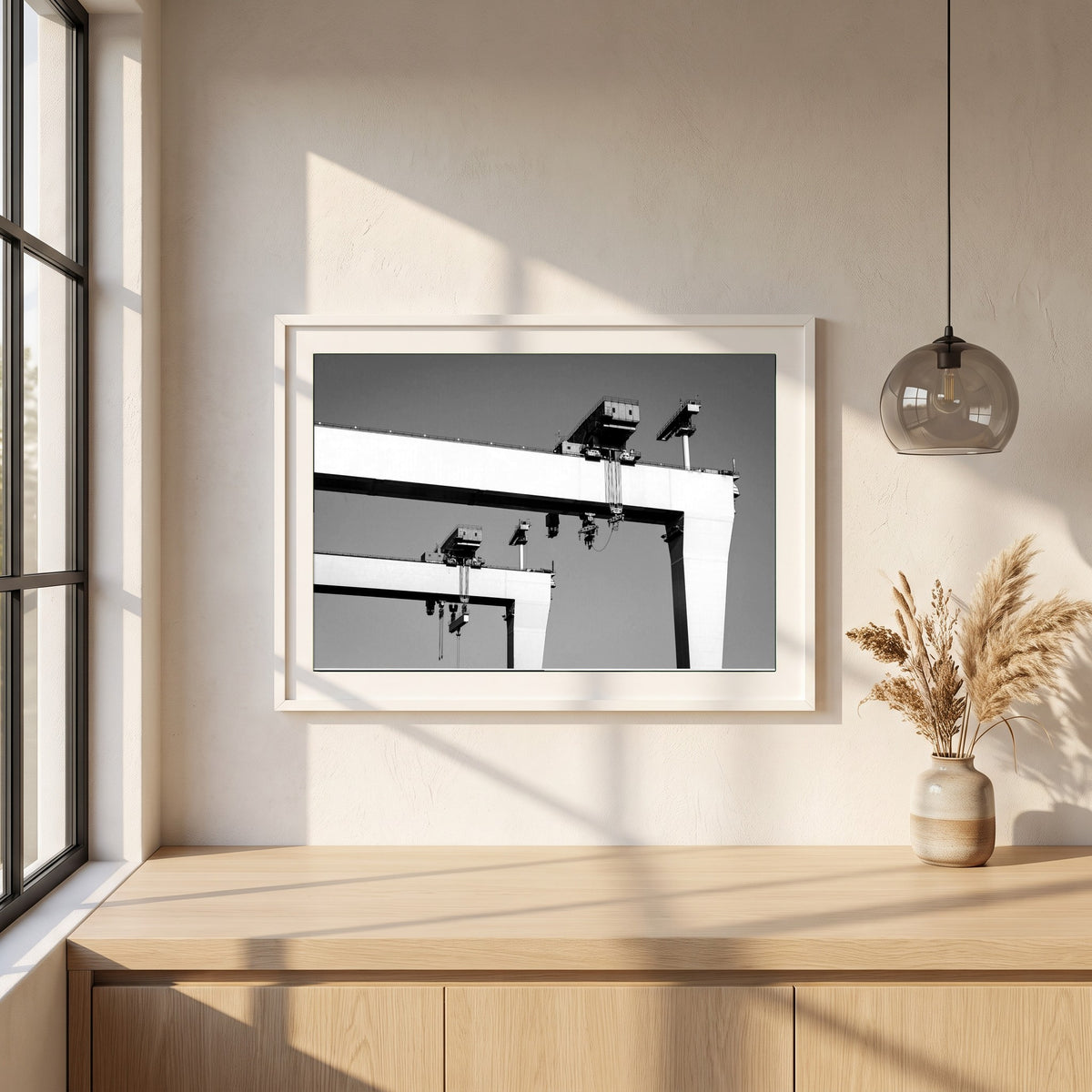 Harland & Wolff Cranes, Belfast framed print in a white frame on a plaster wall above an oak worktop in a bright Scandinavian kitchen