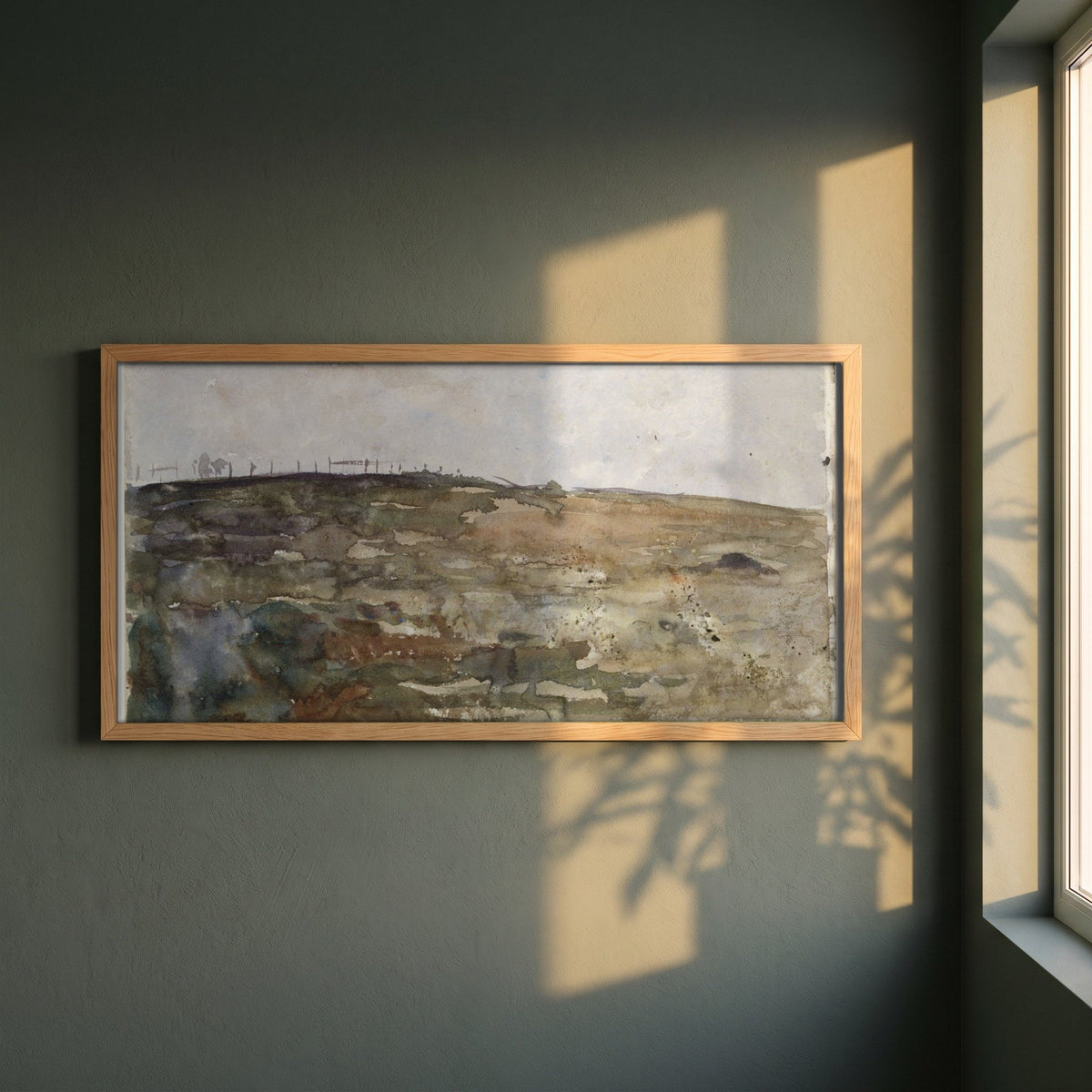 Hillside Heather framed print in a natural oak frame on a dark green wall beside a window, dappled plant shadow