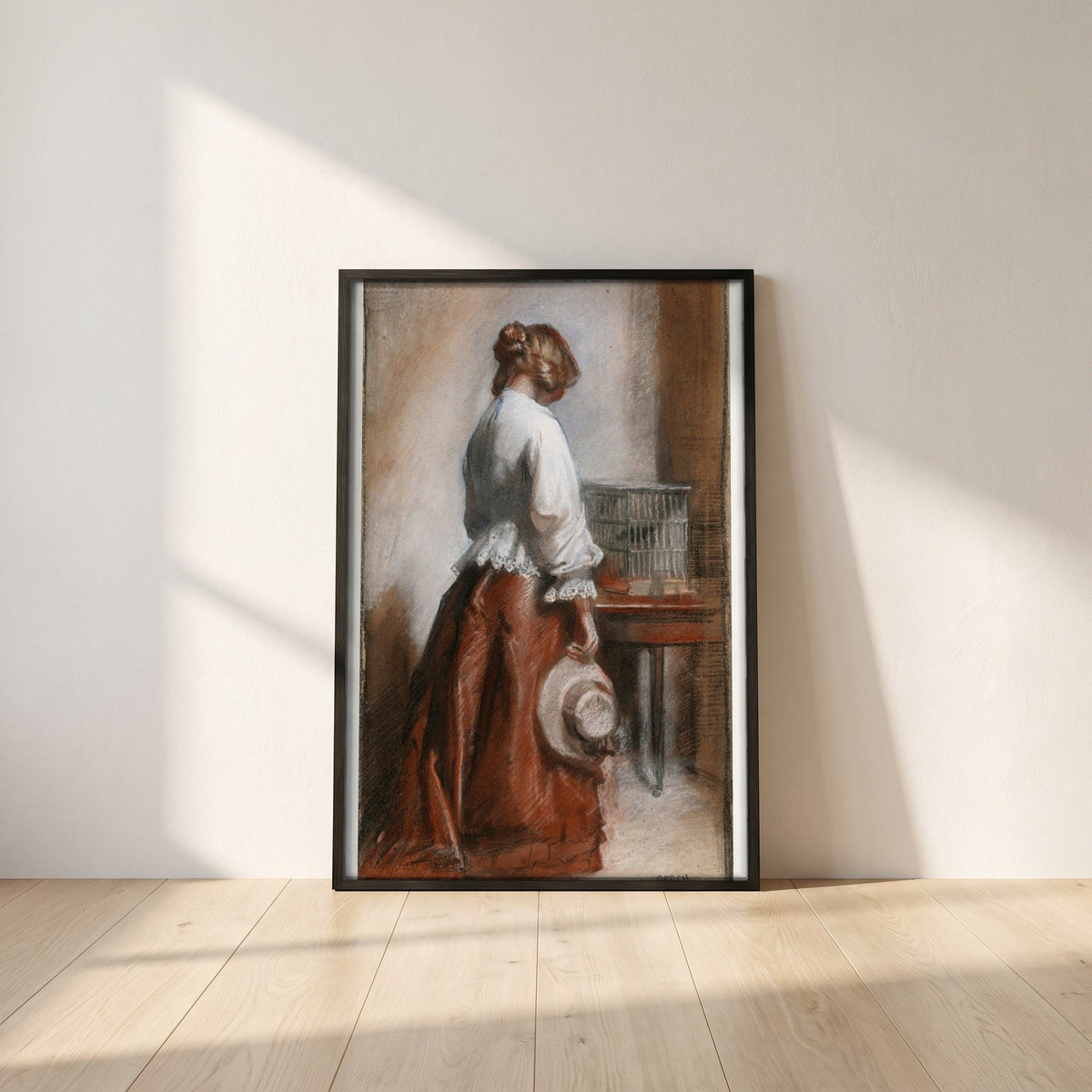 Lady with a Birdcage framed print in a black frame leaning against a white plaster wall on oak floorboards in morning light