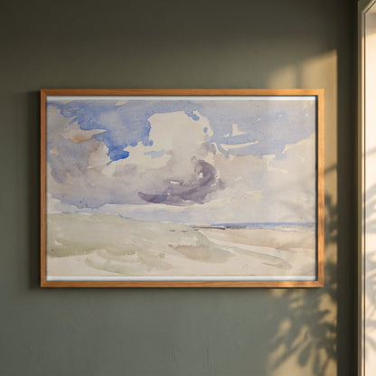 Low Clouds over a Beach framed print in a natural oak frame on a dark green wall beside a window, dappled plant shadow