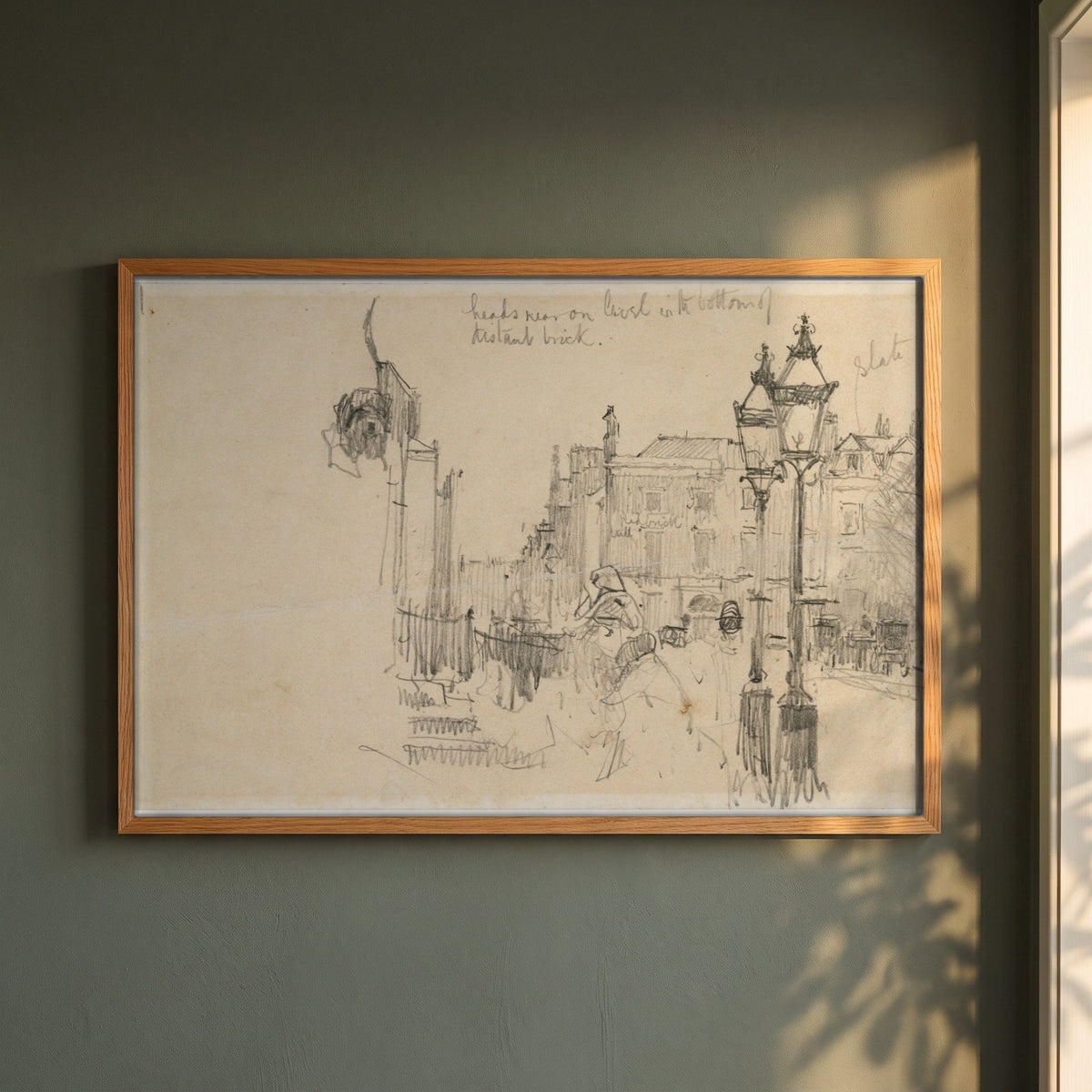 Merrion Row, Dublin, and Tracton House framed print in a natural oak frame on a dark green wall beside a window, dappled plant shadow