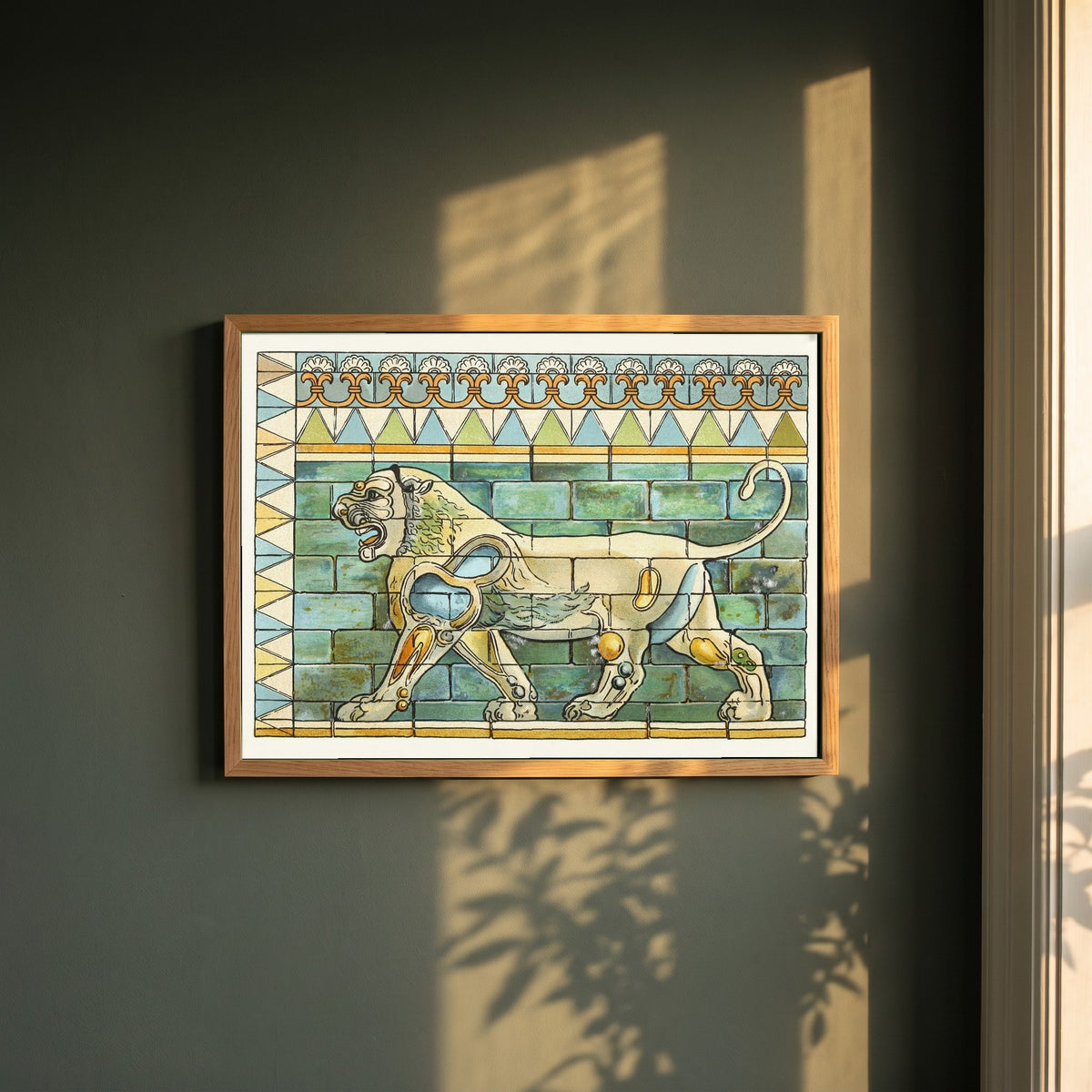 Lions Frieze, Palace of Susa framed print in a natural oak frame on a dark green wall beside a window, dappled plant shadow
