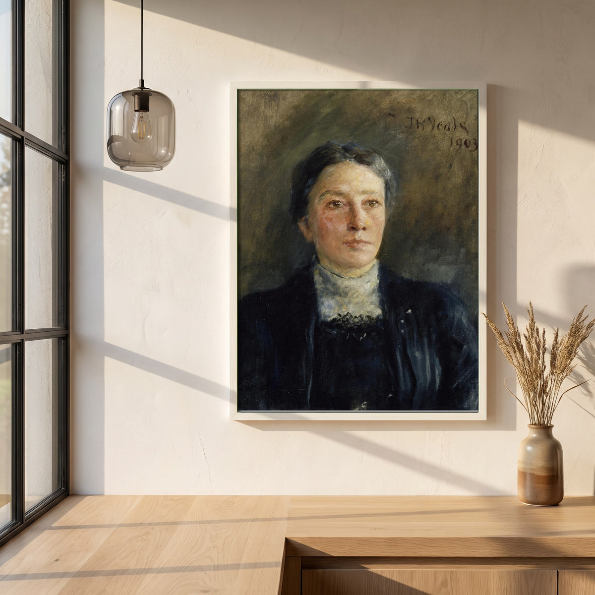 Portrait of Augusta Gregory framed print in a white frame on a plaster wall above an oak worktop in a bright Scandinavian kitchen