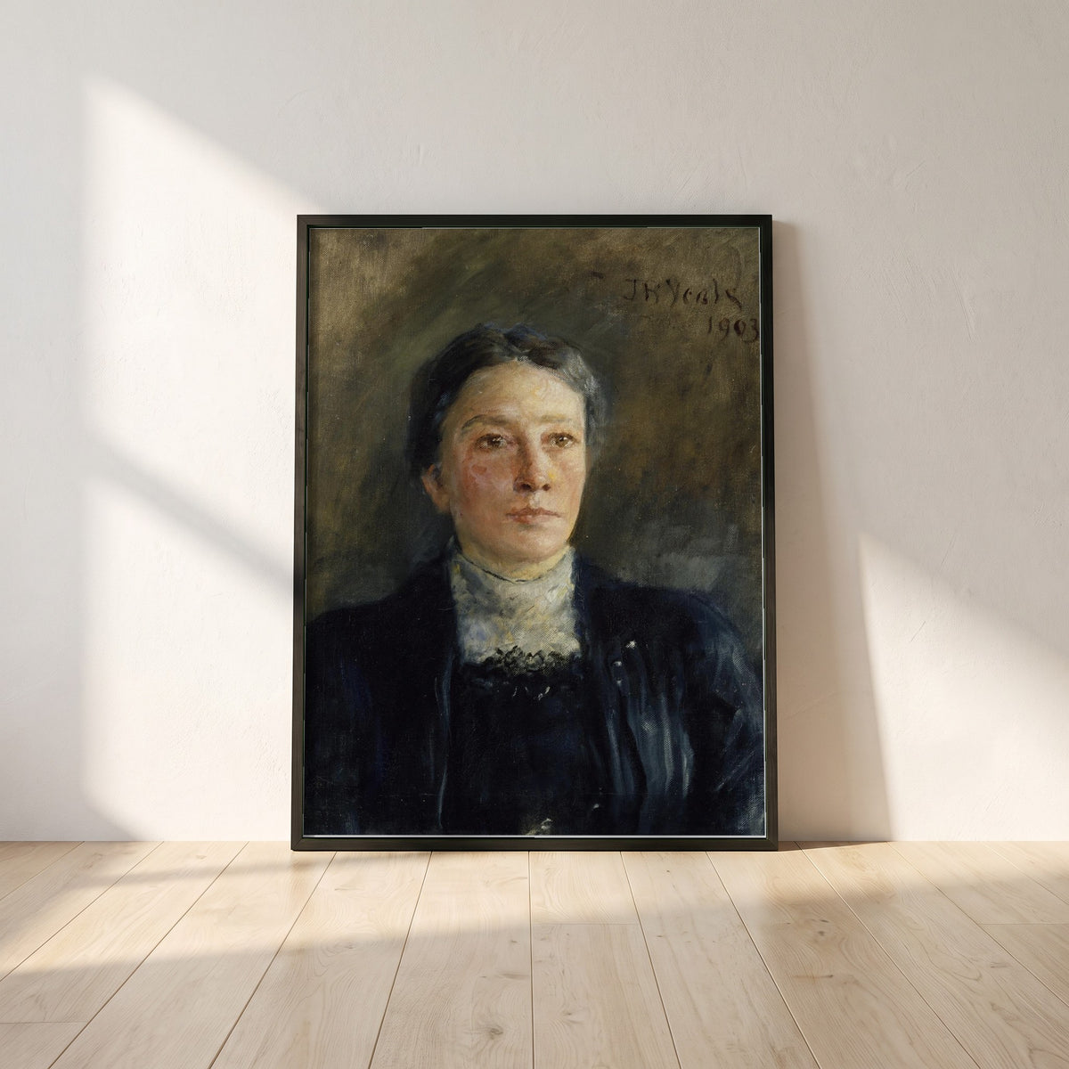 Portrait of Augusta Gregory framed print in a black frame leaning against a white plaster wall on oak floorboards in morning light