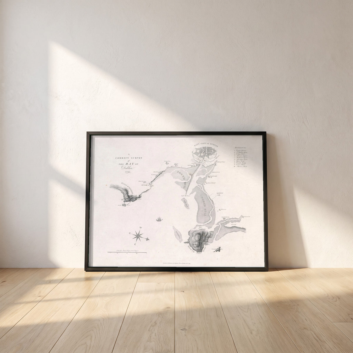 A Correct Survey of the Bay of Dublin, 1795 framed print in a black frame leaning against a white plaster wall on oak floorboards in morning light