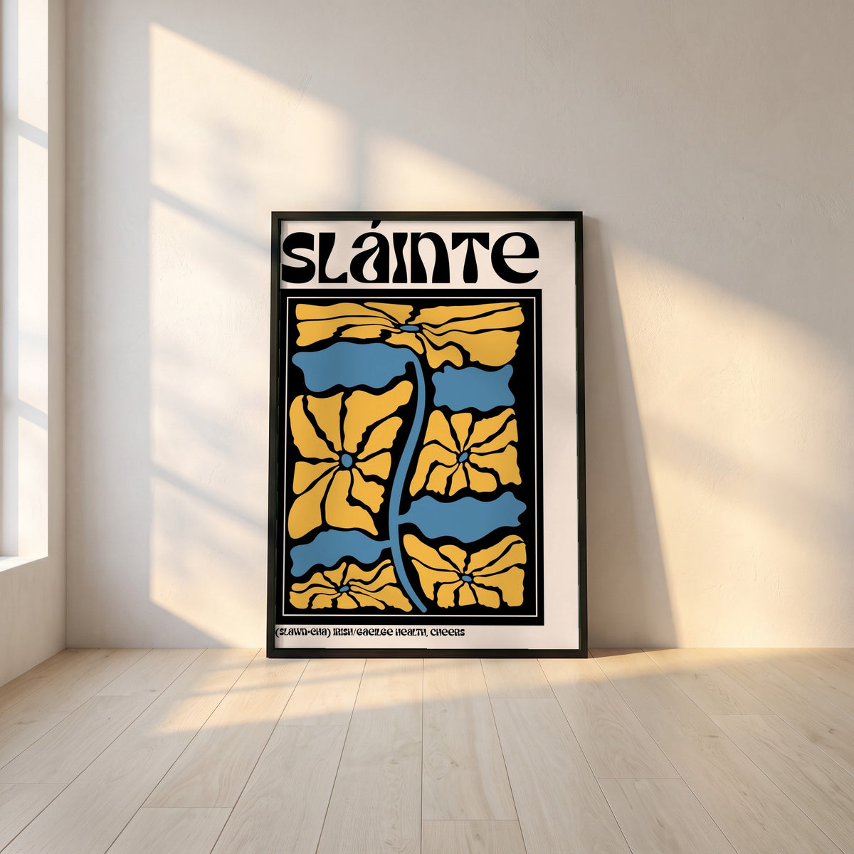 Sláinte framed print in a black frame leaning against a white plaster wall on oak floorboards in morning light