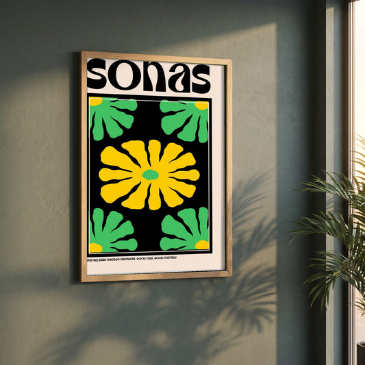 Sonas framed print in a natural oak frame on a dark green wall beside a window, dappled plant shadow