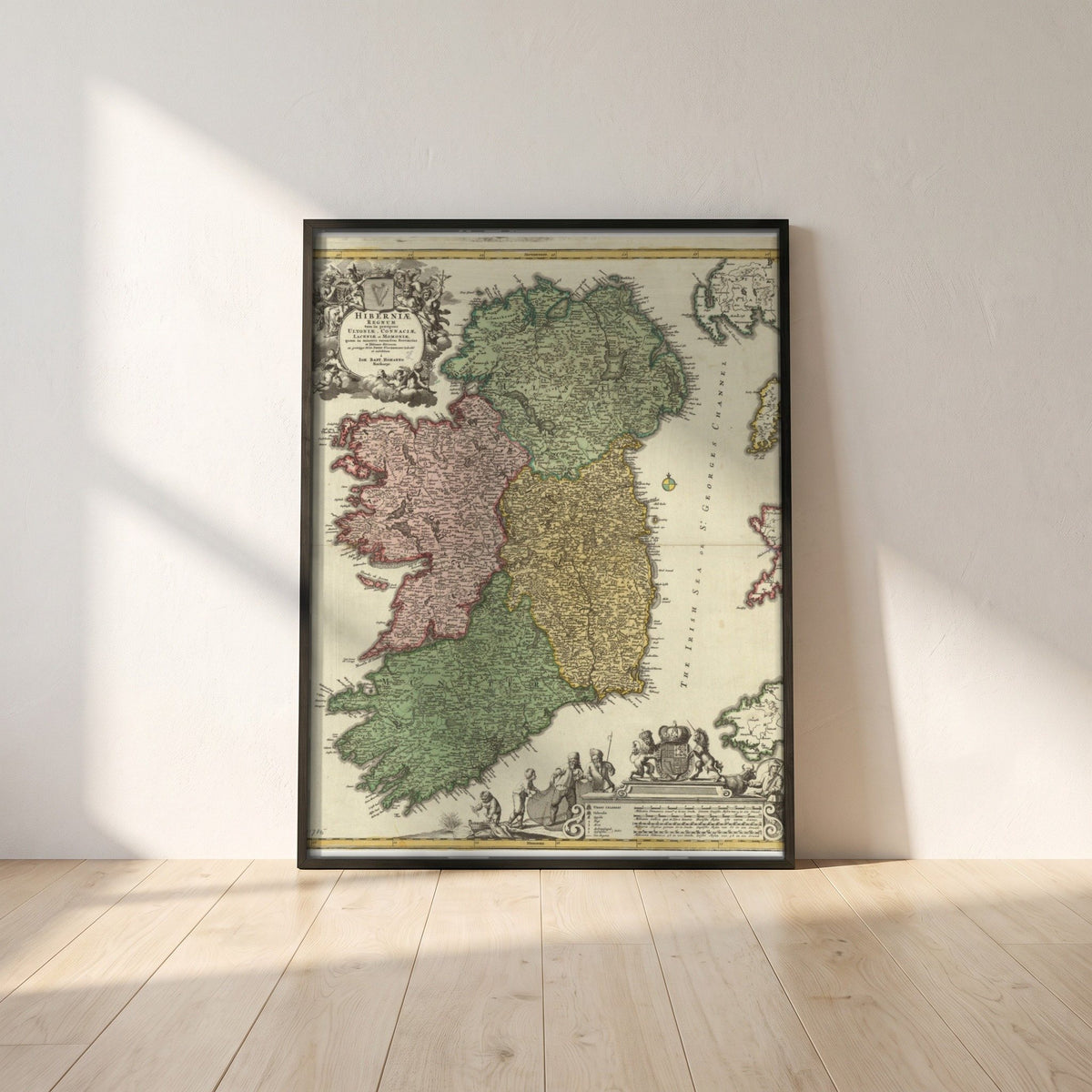 The Kingdom of Ireland map framed print in a black frame leaning against a white plaster wall on oak floorboards in morning light