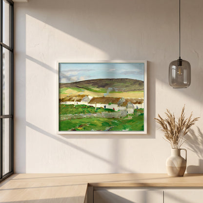 The White Cottage framed print in a white frame on a plaster wall above an oak worktop in a bright Scandinavian kitchen